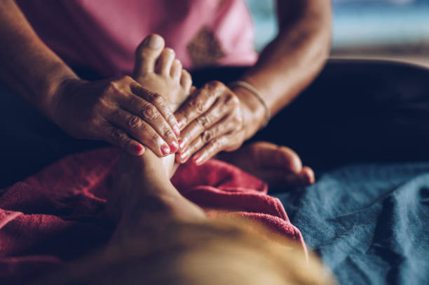Close up of unrecognizable therapist massaging woman's foot at the spa.