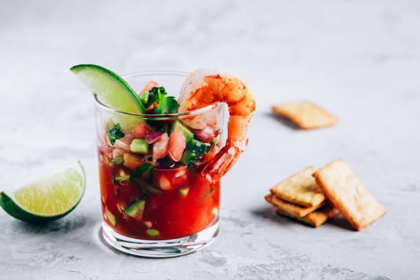 Refreshing Mexican Shrimp Cocktail with lime in glass on gray stone background stock photo