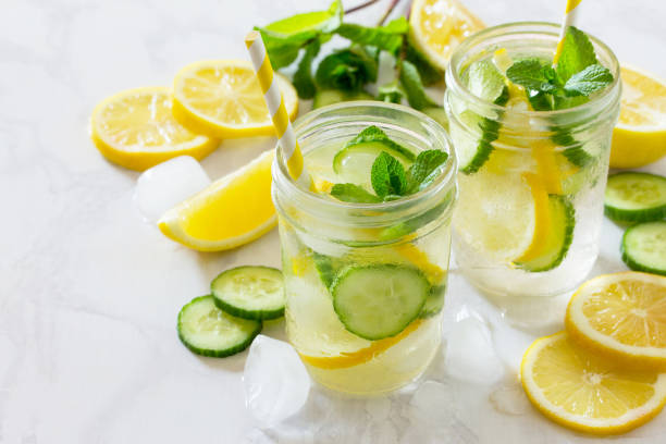 Refreshing summer drink with lemon and cucumber on a background of stone. The concept of eating vegetarians, fresh vitamins, a homemade refreshing fruit drink. stock photo