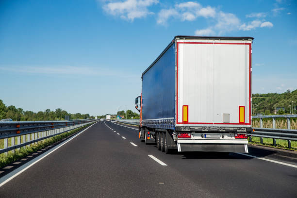 Refrigerated Truck driving on Highway Refrigerated truck driving on highway. semi truck back stock pictures, royalty-free photos & images