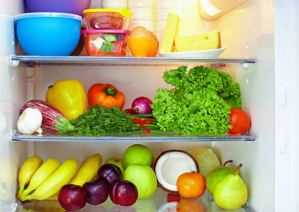 Refrigerators with shelves of fruits and veggies stock photo