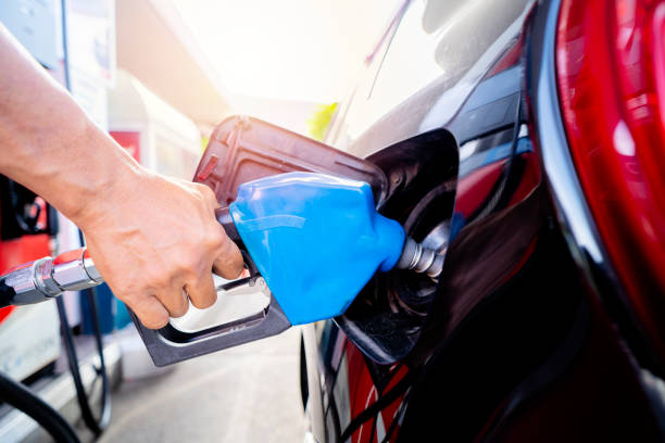 Refuel cars at the fuel pump. The driver hands, refuel and pump the car's gasoline with fuel at the petrol station. Car refueling at a gas station Gas station stock photo