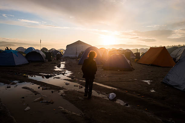 refugee kid among tents - migrants stok fotoğraflar ve resimler