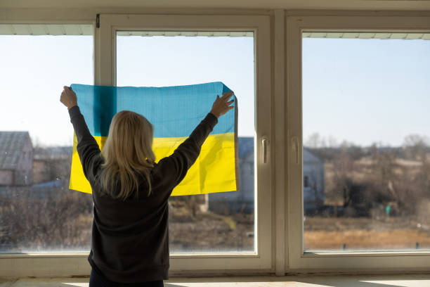 refugee woman with flag of ukraine stock photo