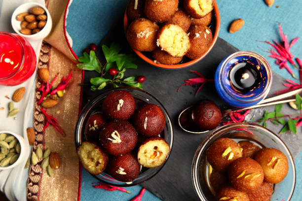 Regional Food Backgrounds: Gulab Jamun, Indian Festival Dessert Indian delicacy Gulab Jamun, 3 varieties of Gulab Jamun in bowl with dry fruits, flowers and candles or diva's background. The picture shows Indian culture and gives the feel of Diwali celebration. mithai stock pictures, royalty-free photos & images