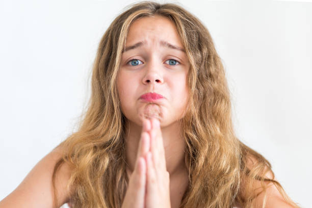 Regretful girl looks gloomy and desperate, keeps palms together, beggs for forgiveness, feels sorry and guilty. Cute adorable girl pleads about something  prayer request stock pictures, royalty-free photos & images