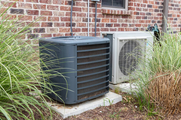 Regular home HVAC air conditioner system and mini-split next to each other. stock photo