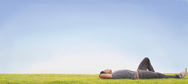 Relax Relaxed young man laying on grass. Blue sky lying down stock pictures, royalty-free photos & images