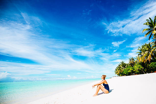 Relaxation at the beach Photo of young woman sitting at the beach in the tropical paradise indian ocean stock pictures, royalty-free photos & images