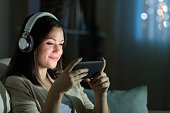 istock Relaxed woman watching video in the night at home 1283544266