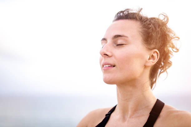 Relaxed young woman meditating outdoors by the sea head close up.  serene people stock pictures, royalty-free photos & images