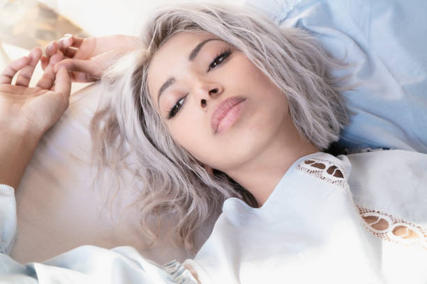 Relaxed young woman portrait lying down Relaxed young woman portrait lying down with blue cold light and white hair white hair young woman stock pictures, royalty-free photos & images