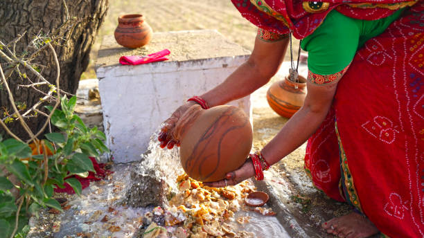 Religious female offering water from clay pot to Lord Shiva statue in a temple. Women offering prayer to God. Women hand pouring out sacred water on God statue. Female hand offering water to exhort god in a temple. chhath stock pictures, royalty-free photos & images