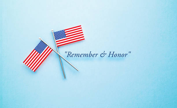 Remember and Honor Memorial Day Message Next to Tiny American Flag Pair Sitting on Blue Background Remember and Honor Memorial Day message next to tiny American flag pair sitting on blue  background. Horizontal composition with copy space. Front view. memorial day background stock pictures, royalty-free photos & images