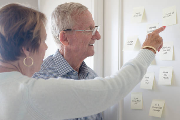Remember! Elderly couple pointing and looking at sticky notes reminders dementia stock pictures, royalty-free photos & images