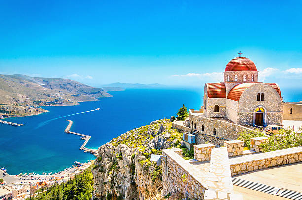 remote church with red roofing on cliff, greece - egeïsche zee stockfoto's en -beelden