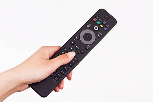 remote in hand remote controller in hand of woman and pushing button remote control stock pictures, royalty-free photos & images