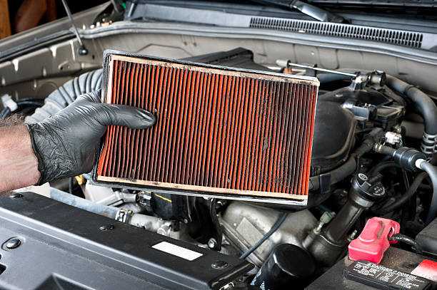 Removing a dirty automotive air filter stock photo