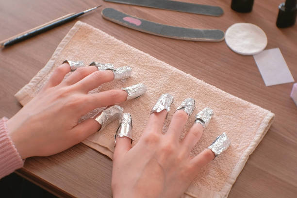 Removing gel Polish from nails. All fingers with foil on both hands. Close-up hand. Front view. Removing gel Polish from nails. All fingers with foil on both hands. Close-up hand. Front view gel nail polish stock pictures, royalty-free photos & images