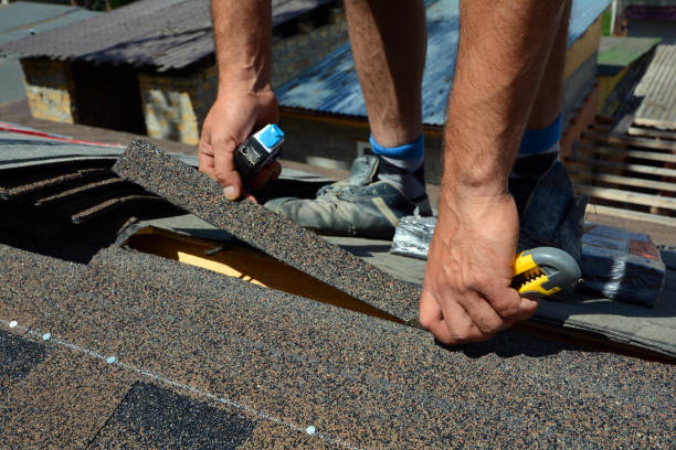 Repairing of roof by cutting felt or bitumen shingles during waterproofing works. stock photo