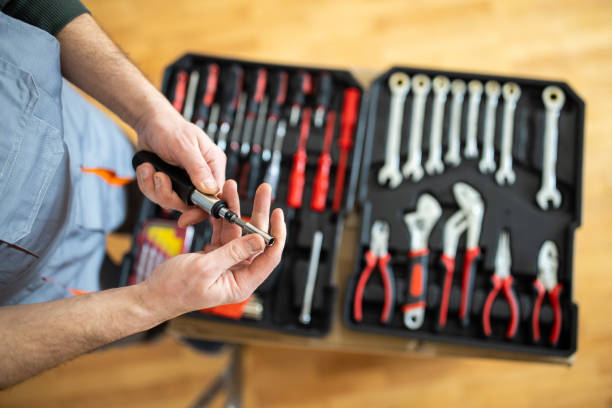 Repairman adjusting screwdriver after picking it from toolbox stock photo