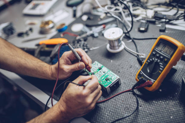 Repairman Checking Voltage With Digital Multimeter Engineer or technician repair electronic circuit board with soldering iron electrical equipment stock pictures, royalty-free photos & images