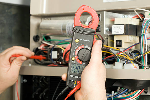 Repairman Checks Voltage on Geothermal HVAC System  furnace stock pictures, royalty-free photos & images