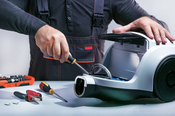 Repairman repairing of vacuum cleaner. stock photo