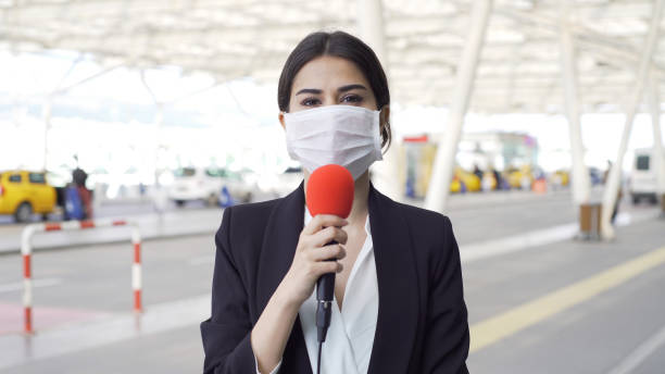 TV reporter wearing a mask TV reporter wearing a mask. journalist stock pictures, royalty-free photos & images