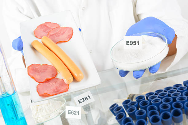 Researcher with food and preservatives Researcher presenting preservatives substances that are added to products such as foods, pharmaceuticals, paints, biological samples, wood etc. food additive stock pictures, royalty-free photos & images