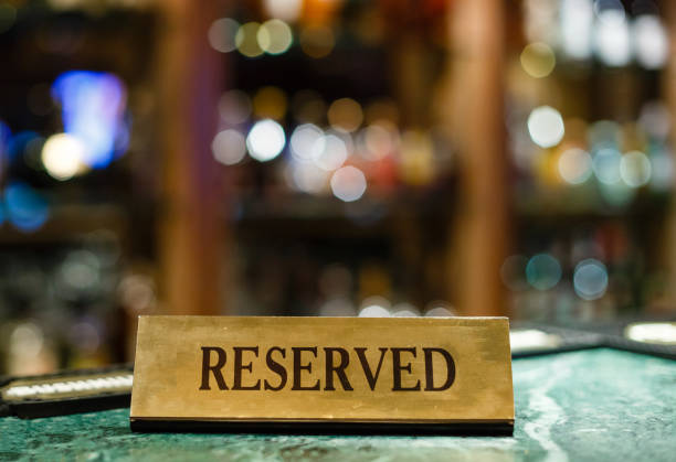 Reserved metal plate with inscription: Reserved on an arranged restaurant white table Reserved metal plate with inscription: Reserved on an arranged restaurant white table bar drink establishment photos stock pictures, royalty-free photos & images