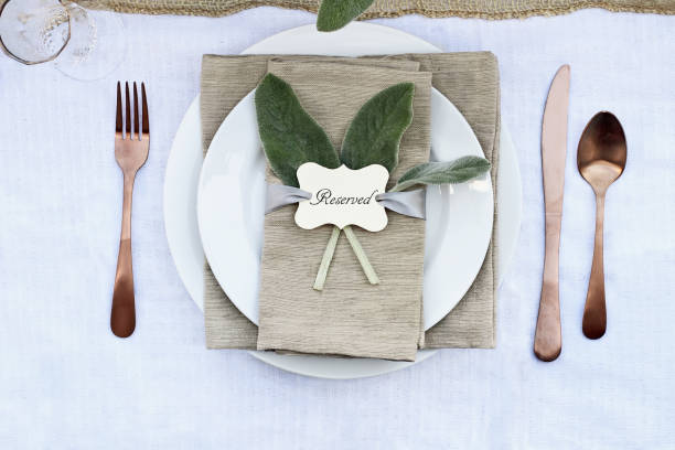 Reserved Place Setting Reserved place setting with Lamb's Ears leaves and copper utensils. Image shot from above. Farmhouse style. thanksgiving diner stock pictures, royalty-free photos & images
