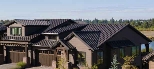 This image shows how attractive brown  metal roofing blends with modern residential architecture. Afternoon side lighting accentuates the pleasing lines of the roofing seams.