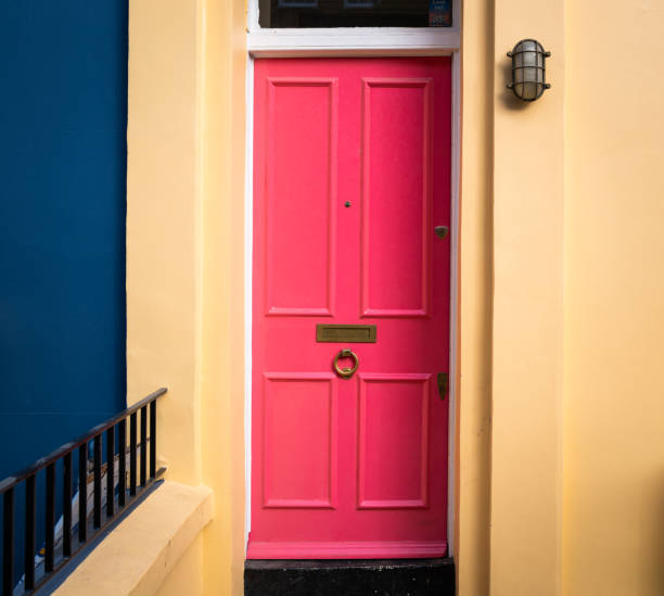 Residential Pink Door in the City Color image depicting the exterior architecture of a terraced residential house in Notting Hill, an affluent area of London, UK. The house has a vibrant pink door. pink front main door stock pictures, royalty-free photos & images