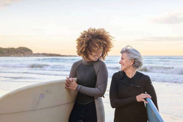 Retired happy woman takes surf lessons stock photo