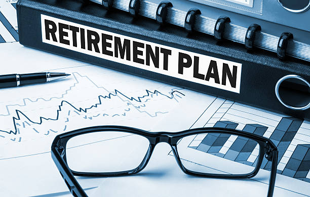 Retirement plan with graphs and glasses on desk stock photo
