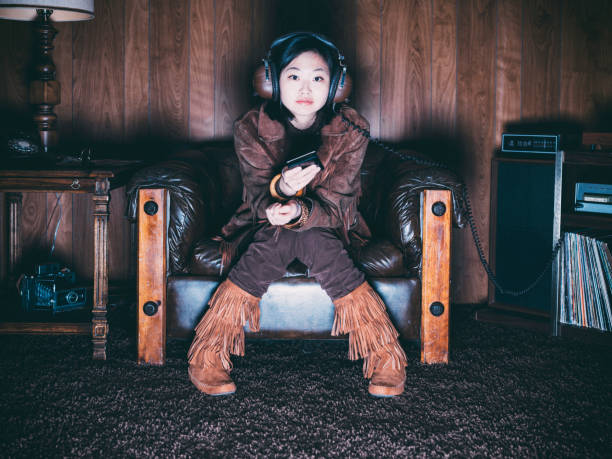 Retro 1970's Girl A young Asian woman wearing retro-styled 1970's clothing. Both the model and set are styled to portray a teenager/young adult from 1976 with period correct clothing, furniture, and props. asian kids watching tv stock pictures, royalty-free photos & images