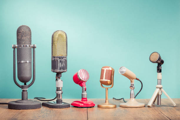 Retro old microphones for press conference or interview recording on table front gradient aquamarine background. Vintage old style filtered photo stock photo
