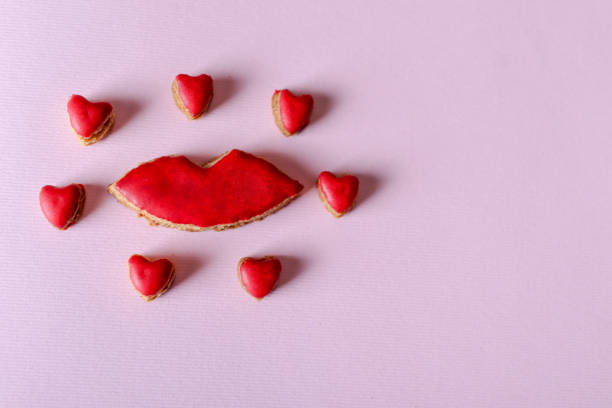 Retro red cookies in shape of lips and hearts isolated on purple background stock photo