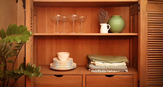 Kitchen retro styled cupboard with dishes-like plates, tablecloths, vases and glasses