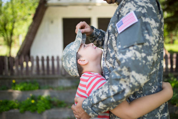 Reuniting after deployment Soldier dad hugs his son after a time in military veterans returning home stock pictures, royalty-free photos & images