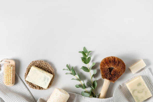 Reusable and natural organic products on background Concept of ecological and recycled objects. Flat lay, top view of natural, organic items for home, coconut brush, luffa sponge, solid soap, towel and eucalyptus plant on white copy space background composition stock pictures, royalty-free photos & images