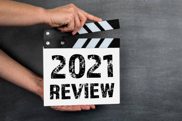 2021 Review concept. White movie clapper on a background of a dark chalk board stock photo
