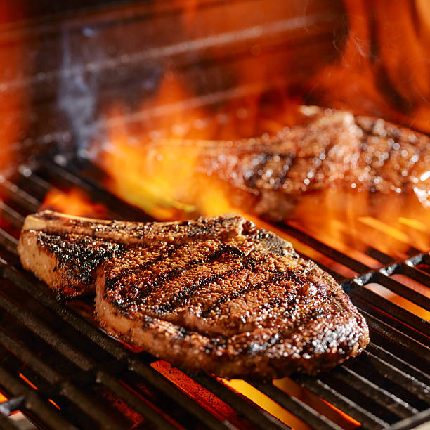 ribeye steaks on the grill over the open flame stock photo