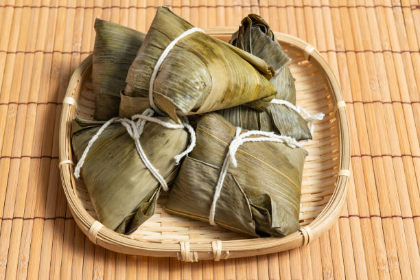 rice dumpling is a traditional Chinese rice dish made of glutinous rice and wrapped in bamboo leaves, Dragon Boat Festival is making and eating zongzi stock photo