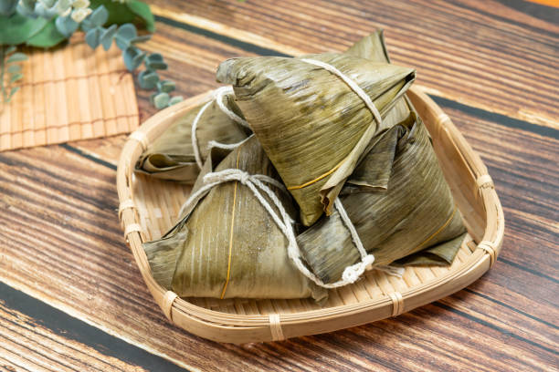 rice dumpling is a traditional Chinese rice dish made of glutinous rice and wrapped in bamboo leaves, Dragon Boat Festival is making and eating zongzi stock photo