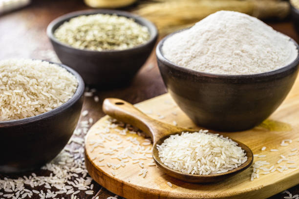 rice flour in clay pot and rustic wooden spoon, vegan ingredient, gluten-free alternative flour and healthier stock photo