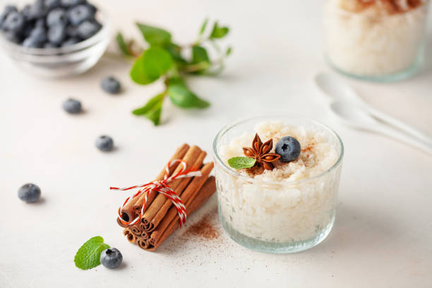Rice porridge or pudding with cinnamon and blueberries in a bowl on the table. Healthy breakfast. stock photo
