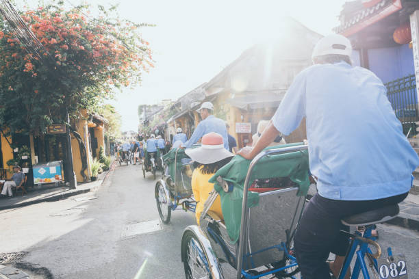 Rickshaws transporting tourists in the historic town center of Hoi An, Vietnam Hoi An, Vietnam - June 2019: bicycle rickshaws transporting tourists in the historic town center unesco organised group stock pictures, royalty-free photos & images