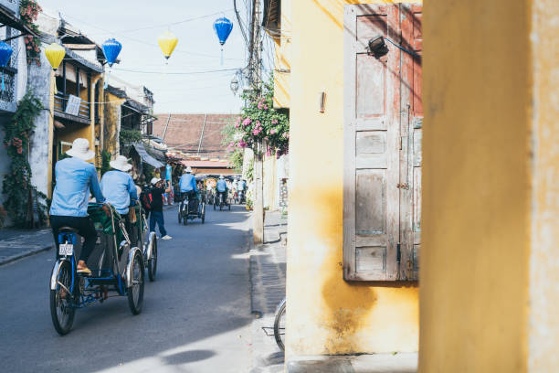 Rickshaws transporting tourists in the historic town center of Hoi An, Vietnam Hoi An, Vietnam - June 2019: bicycle rickshaws transporting tourists in the historic town center unesco organised group stock pictures, royalty-free photos & images